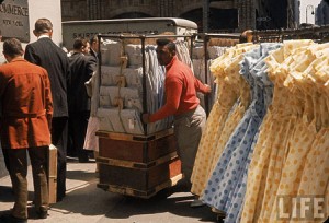 Racks of dresses steered by pushboys in the Garment District, 1960 Racks of dresses steered by pushboys in the Garment District, 1960 by Walter Sanders